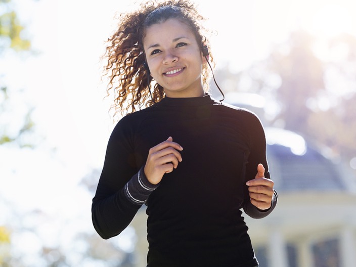 woman jogging outside with music listener